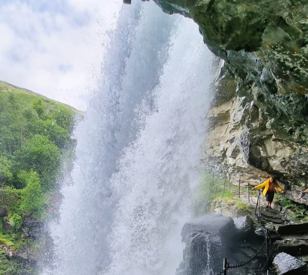 Stepping behind the roaring curtain of water - hike to Storsæterfossen in Geiranger.