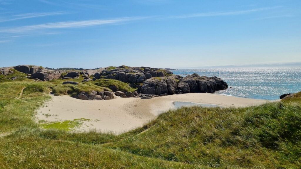 Rocky shoreline and golden sand at Ogna coastal walk, Norway's hidden beaches