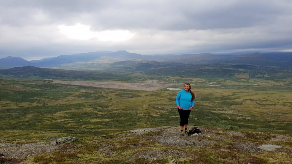 Hiker enjoying panoramic mountain views on an Easy Hike Dovrefjell at Snøhetta Viewpoint