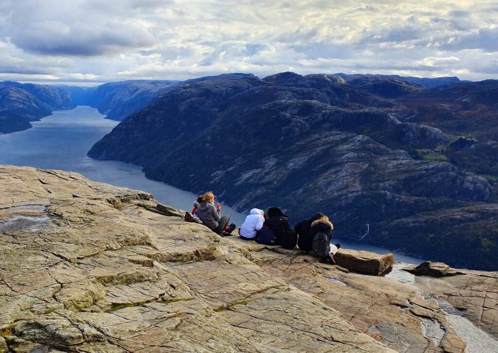 Hikers sitting on Pulpit Rock cliff edge after completing the hike