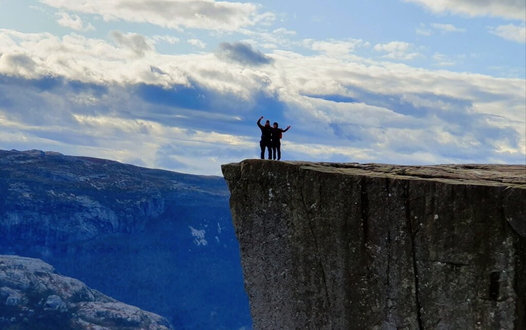 Two happy hikers taking in the epic view from Norway’s most famous plateau - Pulpit Rock